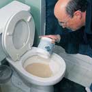 Man applying RootX using the toilet