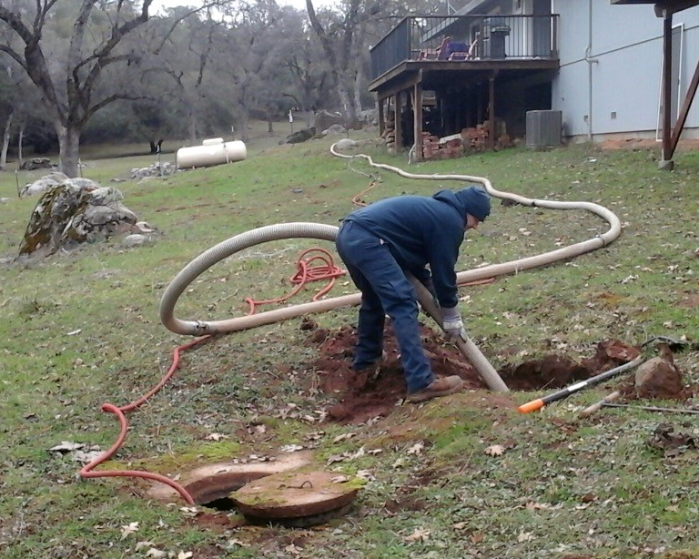 Technician pumping a septic tank